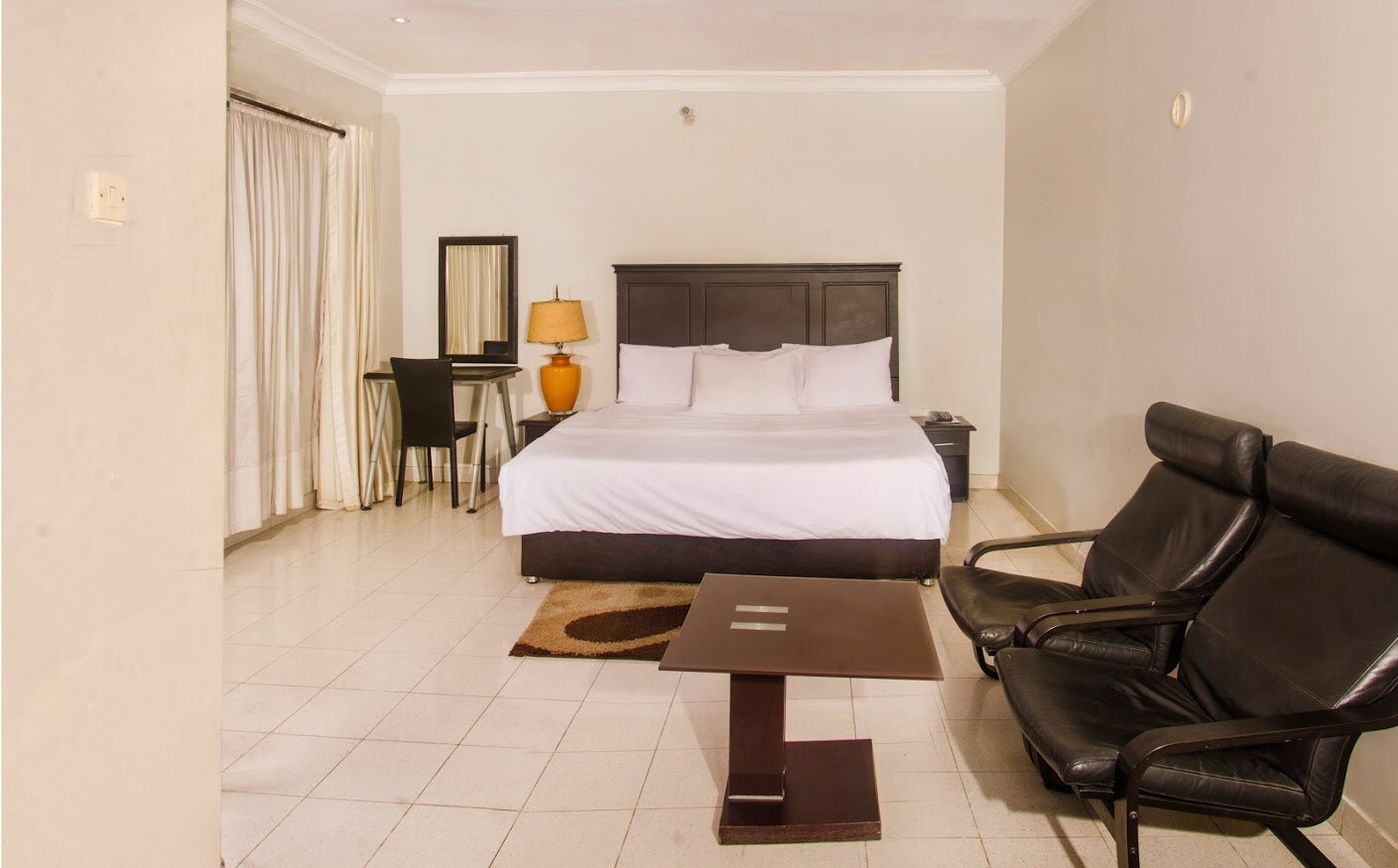 Queen bed and seating area in the Executive Room at Heights Hotels Lekki