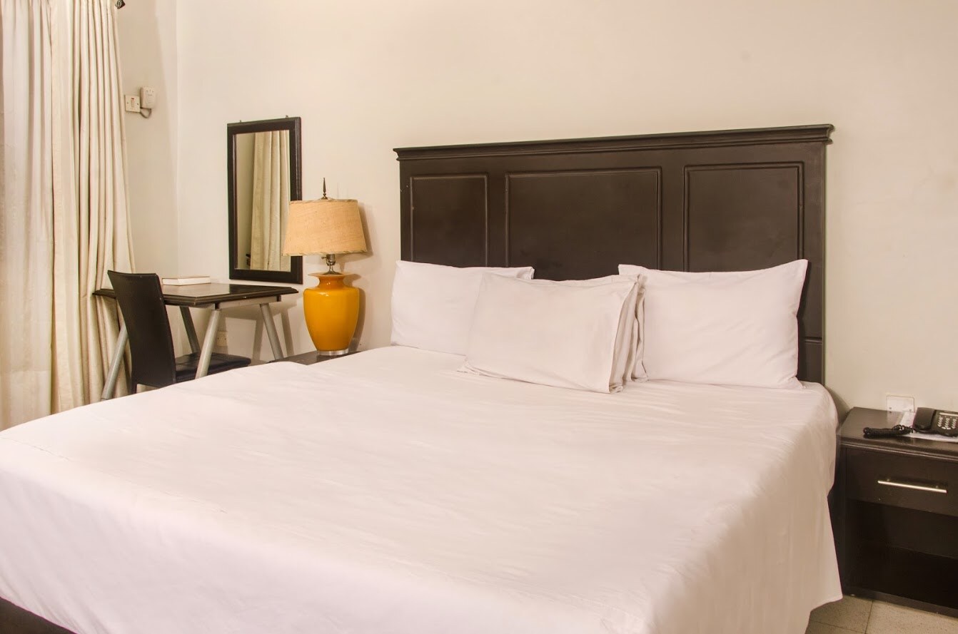 King bed and work desk in the Standard Room at Heights Hotels Lekki